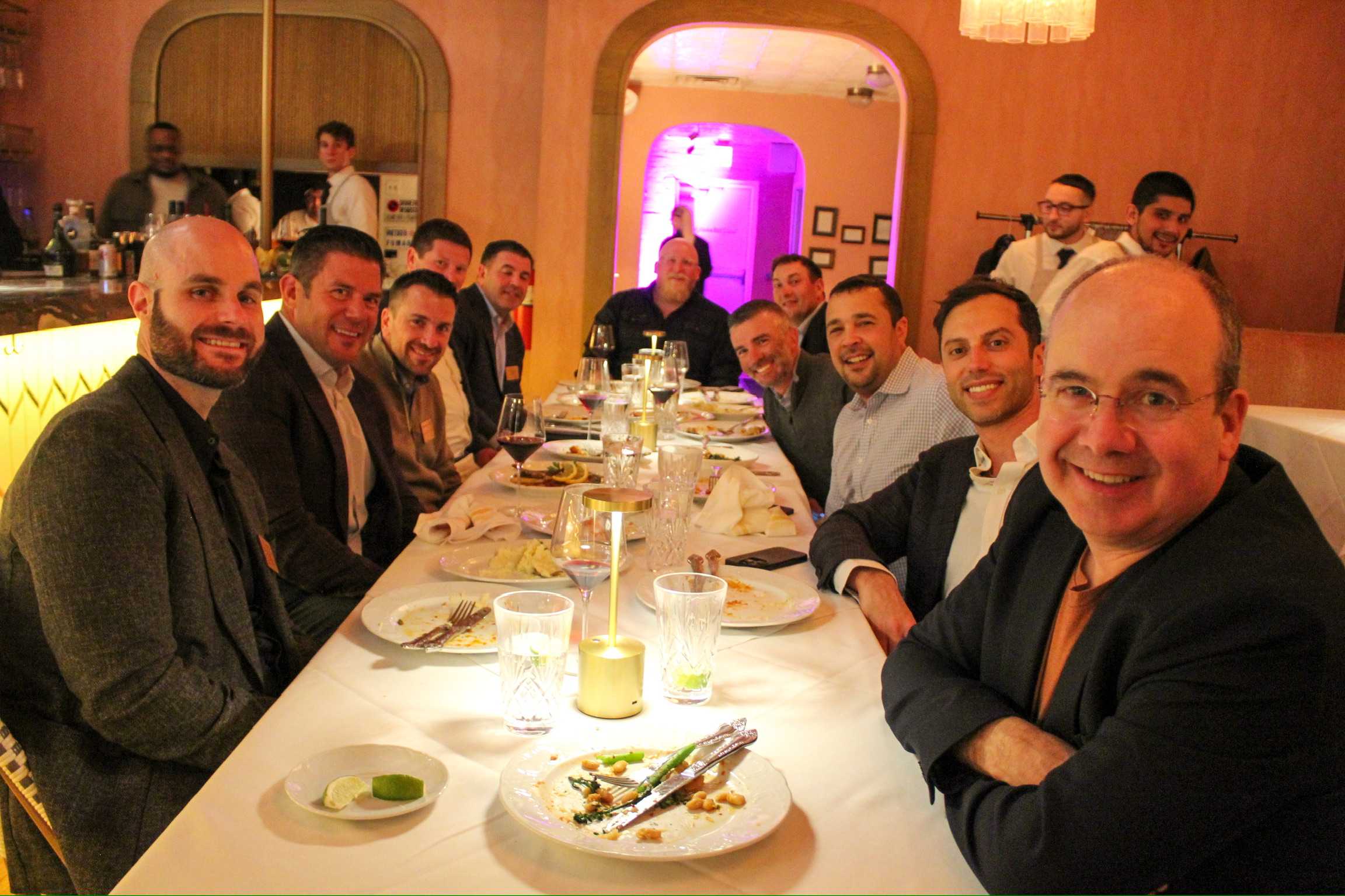 A group of people sitting at a long dinner table