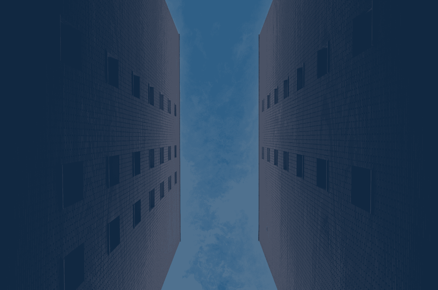 an abstract image looking up at the sky between two tall buildings