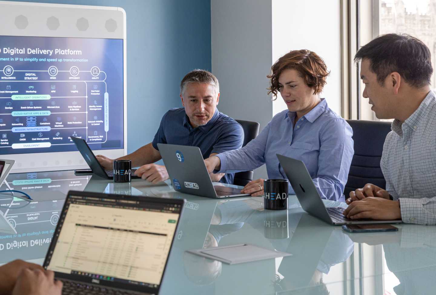 People working together on their laptops and having a discussion in a conference room during a presentation