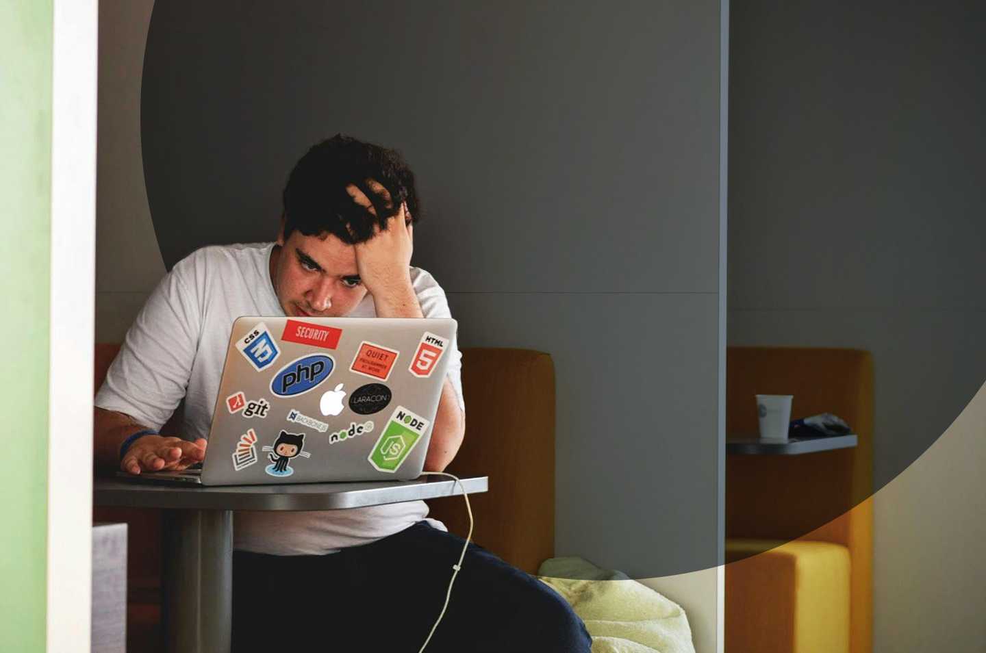 a man looking at a laptop with his hand on his head
