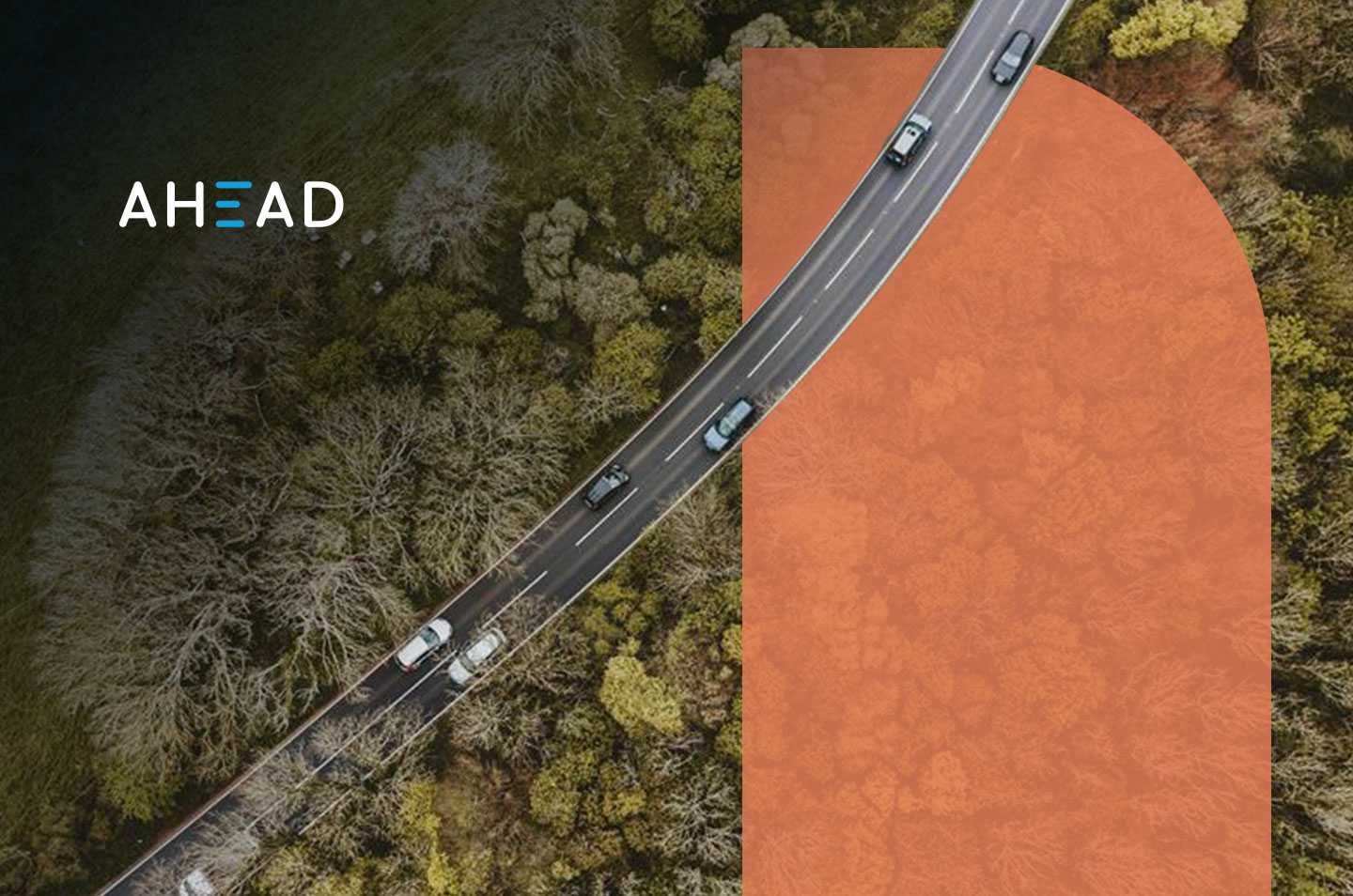 an arial view of a road cutting through a forest