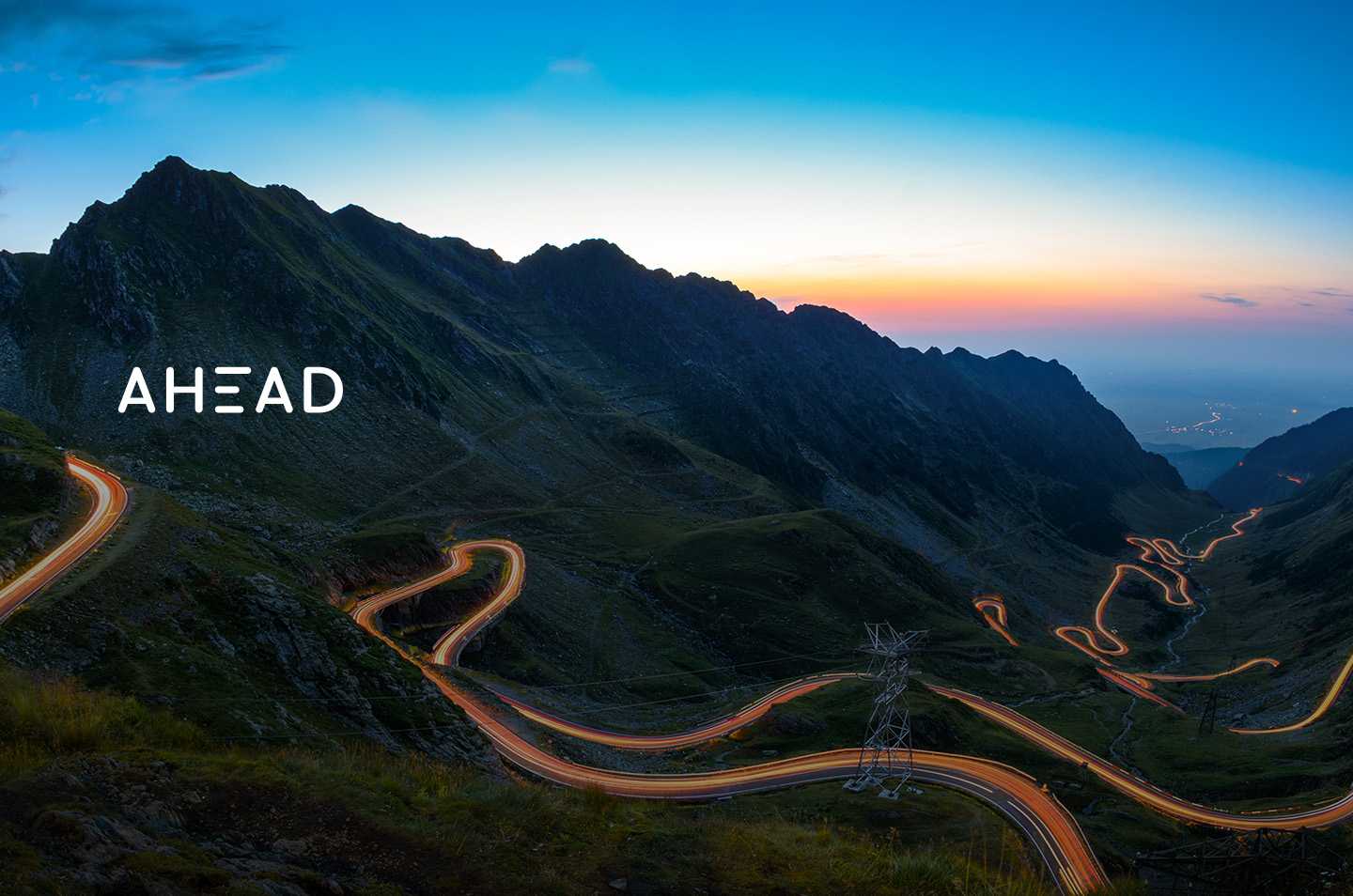 a landscape photo of a winding road through mountains