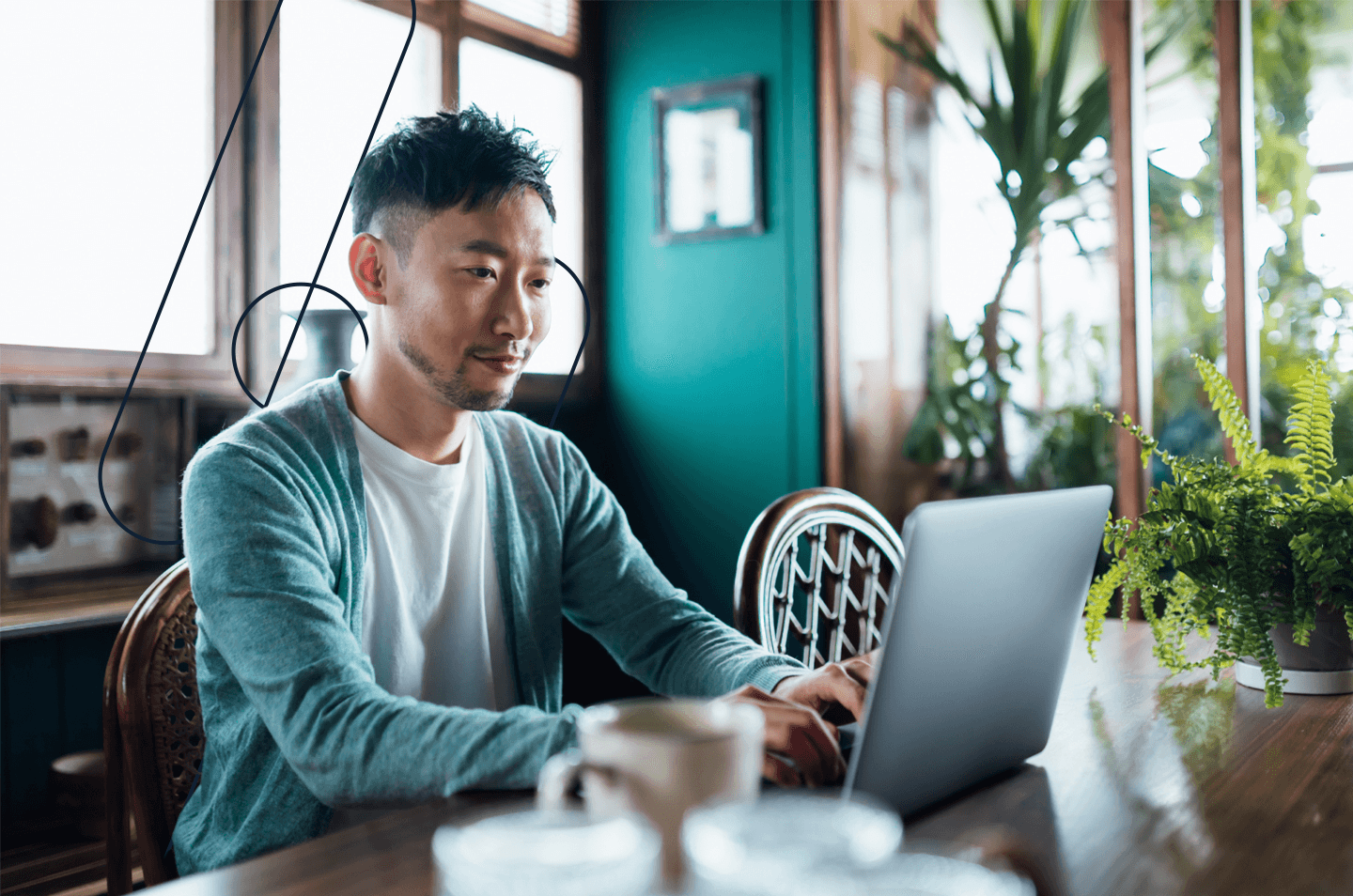 a man sitting at a table working on a laptop