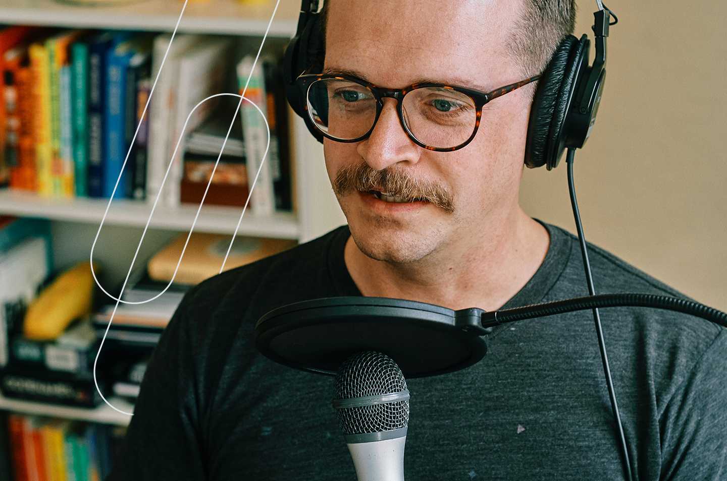 a man sitting in front of a podcast microphone with headphones on
